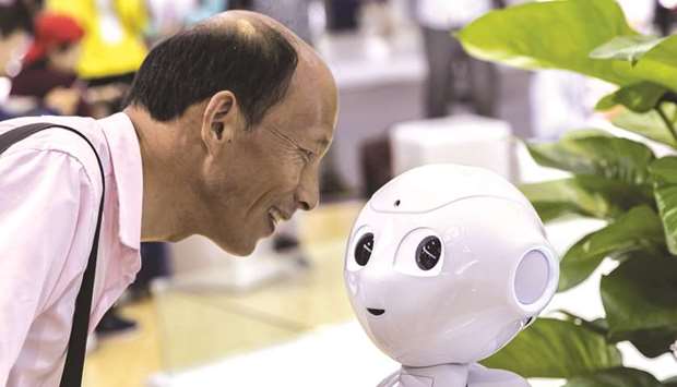 An attendee looks at a CloudMinds Technology Cloud Pepper semi-humanoid robot at the World Artificial Intelligence Conference (WAIC) in Shanghai on August 29. Tech leaders in Asia are warning that risks from ongoing trade tensions are broadening, accelerating the fragmentation of the global industry and threatening collaboration in key research areas.