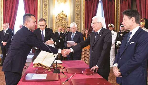 This photo handout issued yesterday by the press office of the Quirinale Presidential Palace shows Foreign Minister Luigi Di Maio thanking President Sergio Mattarella, with Prime Minister Giuseppe Conte (right) in attendance, after signing an oath of office during a swearing-in ceremony of Italyu2019s new cabinet.