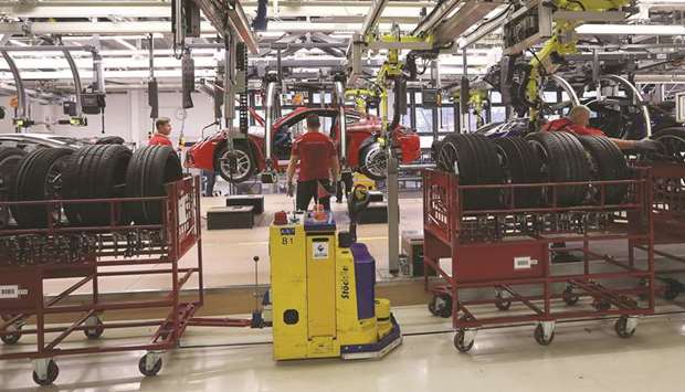 Workers attach wheels to a Porsche 718 luxury automobile on the production line inside the Porsche factory in Stuttgart, Germany. German industrial output unexpectedly fell in July, adding to signs that struggling manufacturers could tip Europeu2019s biggest economy into a recession in the third quarter and supporting the case for the European Central Bank to take action next week.