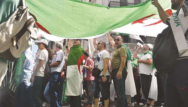 Protesters chant slogans as they march with Algerian national flags during a demonstration against the ruling class in Algiers, yesterday.