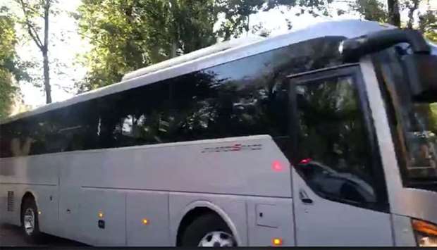 Buses with tinted windows leaving the high-security prison