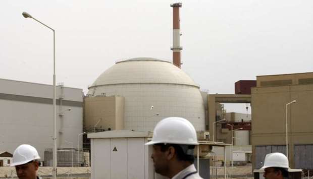 In this file photo taken on February 25, 2009, Iranian technicians walk outside the building housing the reactor of Bushehr nuclear power plant at the Iranian port town of Bushehr