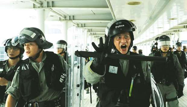 Riot police advance in Tung Chung station, in Hong Kong yesterday.