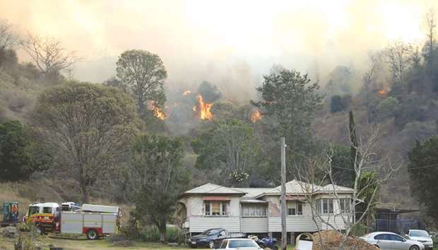 Fire and Emergency crew battle bushfire near a house in the rural town of Canungra in the Scenic Rim region of South East Queensland yesterday.