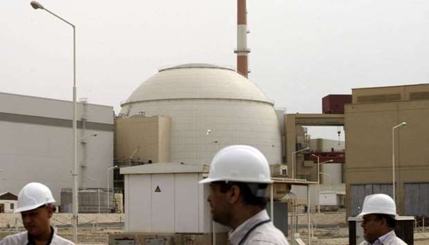 Iran technicians walk outside the building housing the reactor of Bushehr nuclear power plant