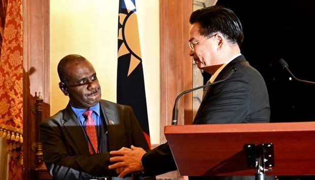 Taiwan's Foreign Minister Joseph Wu (R) shakes hands with Solomon Islands' Foreign Minister Jeremiah Manele (L) during a press conference at the Taipei Guest House in Taipei