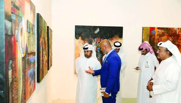 Artist Ali Ghaddaf briefs Dr Khalid bin Ibrahim al-Sulaiti on his works.