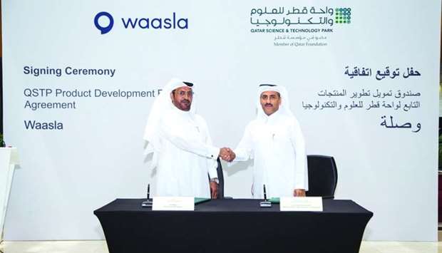 Waasla founder and CEO Ali al-Marri (L) and QSTP executive director Yosouf Abdulrahman Saleh shake hands after signing the agreement.