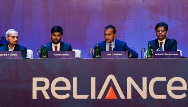 Indian tycoon Anil Ambani (C), Chairman of Reliance Group, addresses shareholders as his son Anmol (3L) looks on in Mumbai. (file photo)