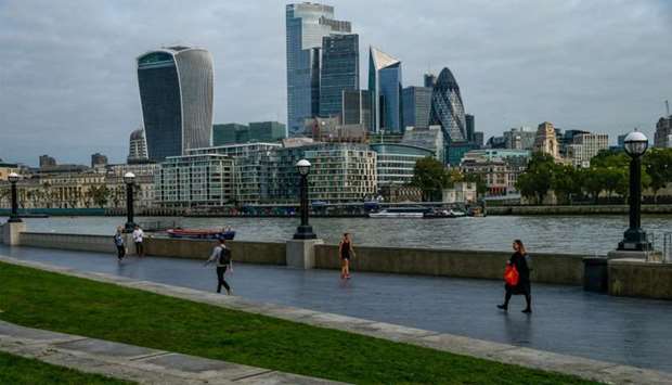 Commuters walk along the Thames Path in view of skyscrapers in the City of London square mile financial district in London, U.K., on Friday, Sept. 11, 2020. Britain recorded strong economic growth in July as coronavirus restrictions eased, but mounting job losses and the risk of a messy Brexit are threatening a turbulent end to the year. Photographer: Hollie Adams/Bloomberg