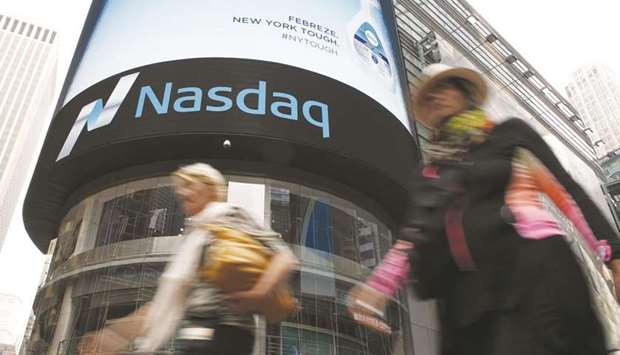 Women walk past the Nasdaq MarketSite in New Yorku2019s Times Square. With the Nasdaq 100 swooning 4.8% to cap a three-day, 11% correction, a gauge of index turbulence that is partly a reflection of options prices also dropped, another in a series of unified moves that has now lingered for two weeks.