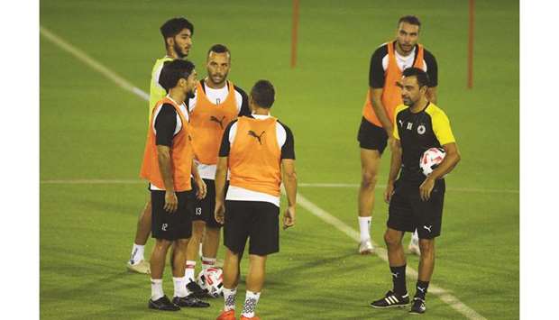 Al Sadd coach Xavi Hernandez with his players during a training session.