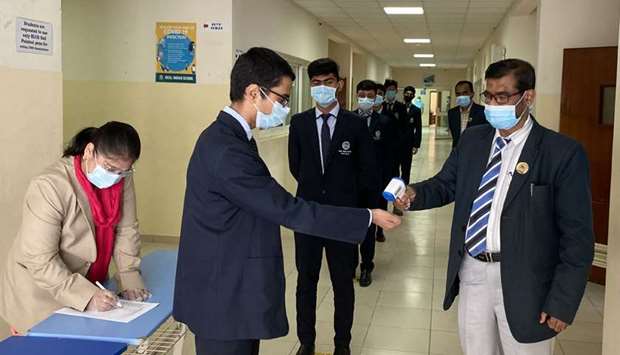 Students' temperature being checked at Ideal Indian School on Tuesday.