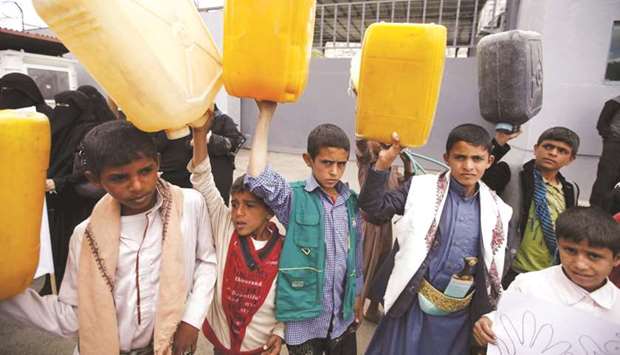 Boys hold up jerrycans to represent drinking water during a protest against a Saudi blockade of Yemenu2019s ports, outside the United Nationsu2019 offices in Sanaa, Yemen.