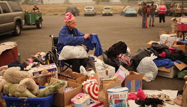 A woman looks through clothes at a makeshift distribution centre for people displaced by the wildfires at a parking lot in Oregon City, Oregon, US, yesterday.