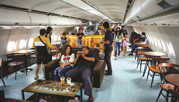 Visitors enjoying drinks in a retired Airbus 330 air-plane turned into a coffee shop at an attraction site, outside Pattaya in Chonburi province.