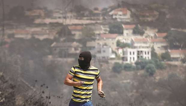 A Palestinian demonstrator runs during a protest against normalising ties with Israel, in Kafr Qaddum town in the Israeli-occupied West Bank.