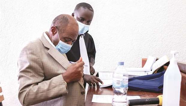 Paul Rusesabagina stands with his lawyer Rugaza David inside the Kicyikuri primarily court in Kigali yesterday.