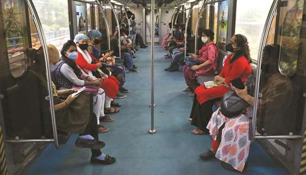 Passengers wearing protective masks travel inside a metro train on the first day of the restart of the metro operations, amid the spread of the coronavirus disease, in Kolkata, yesterday.