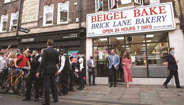 People watch from the windows above Beigel Bake Brick Lane Bakery as Prince William and his wife Catherine leave after visiting the bakery in east London yesterday. The 24-hour bakery was forced to reduce their opening hours during the pandemic and The Duke and Duchess heard how this affected employees, as well as the ways in which the shop has helped the local community through food donation and delivery.
