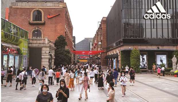 Shoppers and pedestrians walk past a Nike Inc store, left, and an Adidas store in a shopping precinct in Wuhan. Chinau2019s retail sales gained 0.5% in August from a year earlier, while industrial production rose 5.6% in the period, the National Bureau of Statistics said yesterday.