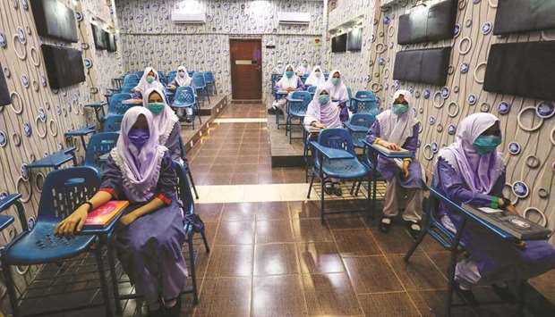 Students keep a safe distance while attending an audio-visual class, as schools reopen amid the coronavirus pandemic in Karachi, Pakistan.