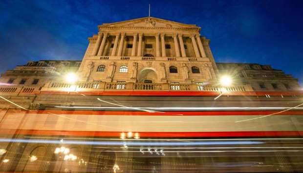 A double-decker bus leaves light trials as it passes the Bank of England in the City of London. While economists and investors donu2019t see immediate action, they widely predict the BoEu2019s bond-buying programme will be expanded again before the end of the year.