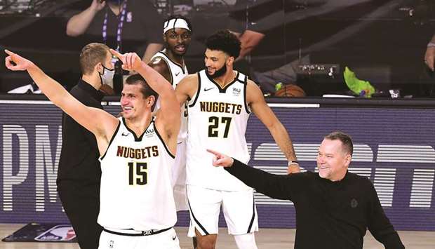 Michael Malone, Nikola Jokic and Jamal Murray of the Denver Nuggets celebrate their win over LA Clippers in Game Seven of the Western Conference Second Round at AdventHealth Arena at the ESPN Wide World Of Sports Complex on Tuesday in Lake Buena Vista, Florida.