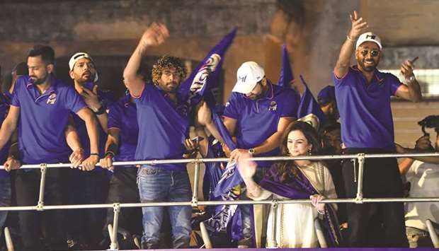 In this file photo taken on May 13, 2019, Mumbai Indians players Lasith Malinga (3L), Rohit Sharma (C), Hardik Pandya (R) and others travel in an open bus during a celebration procession after arriving in Mumbai. Already regarded as the worldu2019s richest and most successful Twenty20 team, the Mumbai Indians will attempt to underline their status by claiming their first back-to-back titles in the Indian Premier League.