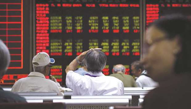Investors look at screens showing stock market movements at a securities company in Beijing. The Composite closed up 2.1% to 3,338.09 points yesterday.