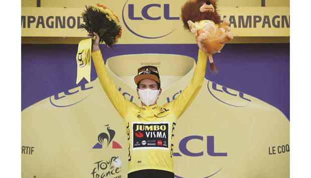 Team Jumbo-Visma rider Primoz Roglic of Slovenia, wearing the overall leaderu2019s yellow jersey, celebrates on the podium, after Stage 19 of the Tour de France yesterday. (Reuters)