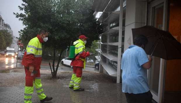 Municipal workers disinfect the entrance of a health center in the Usera district of Madrid