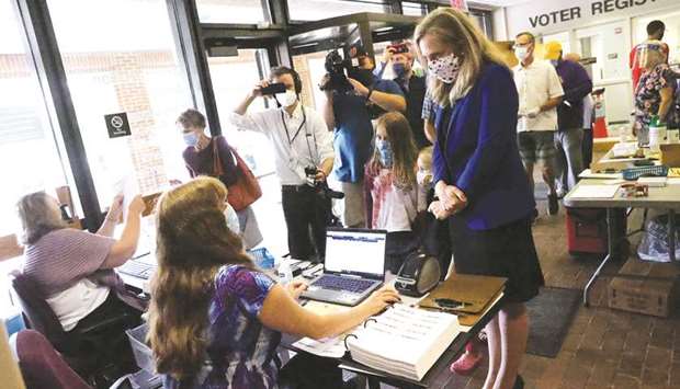 Representative Abigail Spanberger (D-VA) checks in with poll workers before voting at the Henrico County Registraru2019s office with her daughters Catherine, Charlotte and Claire in Henrico, Virginia, yesterday.