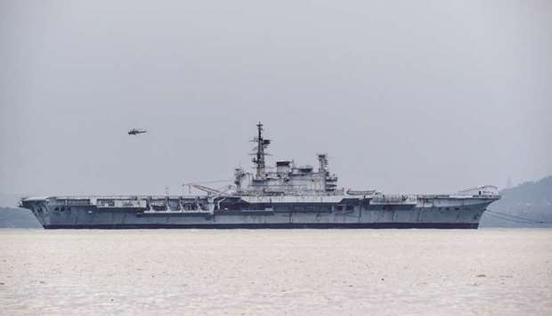 Indian Navyu2019s decommissioned aircraft carrier INS Viraat is towed by boats as a helicopter hovers above on the shipu2019s final journey to the Alang Ship breaking yard in Gujarat, from the naval dockyard in Mumbai yesterday.