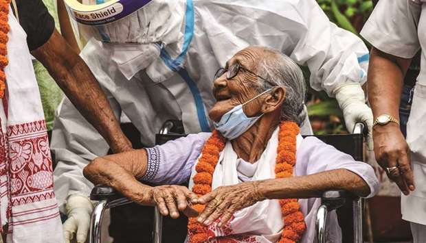 A nurse pushes a wheelchair carrying Mai Handique, 101, as she is discharged after being treated for Covid-19 at Mahendra Mohan Choudhury Hospital, in Guwahati.
