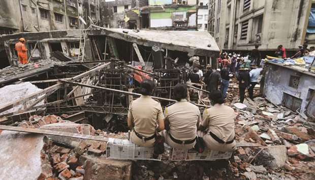 Police officers watch rescue operations after a three-storey building collapsed in Bhiwandi, on the outskirts of Mumbai, yesterday.