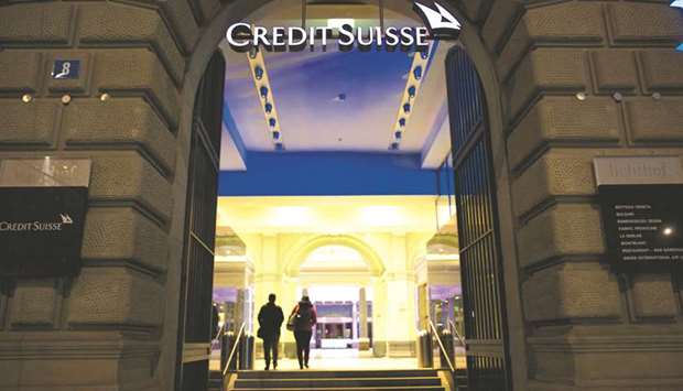 An illuminated Credit Suisse logo sits above the entrance to its headquarters in Zurich. Credit Suisse this month hired a dozen analysts in China, almost half of whom used to work at UBS Group. UBS has scooped up more than 40 people from global and local firms.