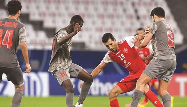 Al Duhailu2019s Almoez Ali (left) and teammate Luiz Junior (right) vie for the ball with Persepolisu2019 Vahid Amiri during their AFC Champions League Group C match at Education City Stadium on Monday. (Twitter/TheAFCCL)