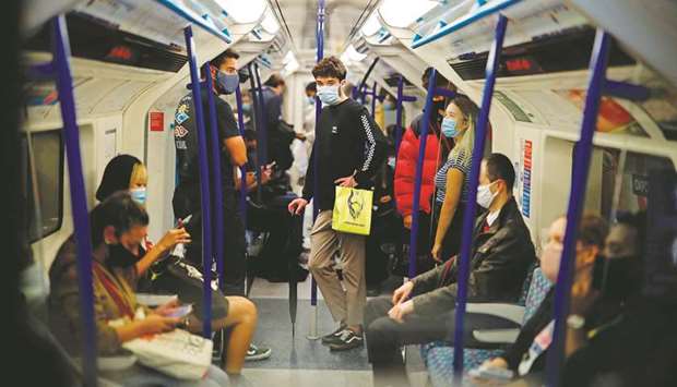Commuters wearing protective face coverings travel on Victoria line at rush hour in central London yesterday.