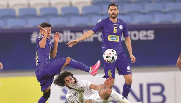 Esteghlalu2019s Mehdi Ghaedi (left) vies for the ball with Al Ahli Saudiu2019s Hussein Abdulghani (centre) as Esteghlalu2019s Ali Karimi looks on during their AFC Champions League Group A match at Al Janoub Stadium yesterday. PICTURE: Noushad Thekkayil