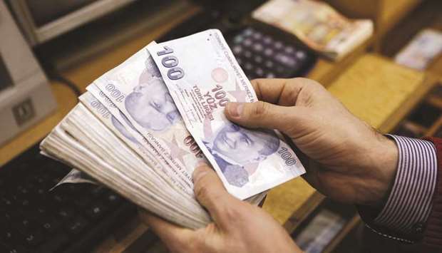 A money changer counts Turkish lira bills at a currency exchange office in central Istanbul (file).