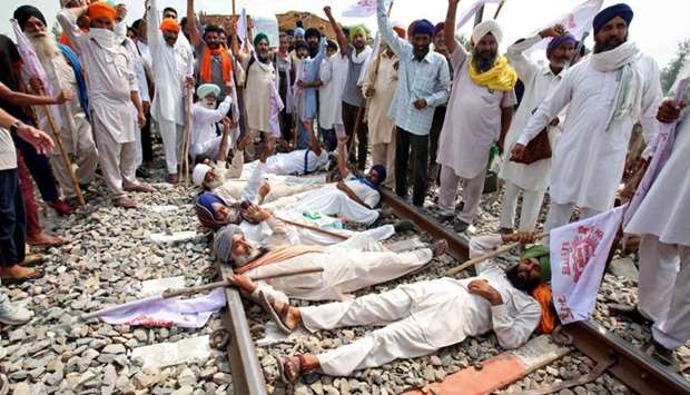 Farmers shout slogans as they block a railway track during a protest against farm bills passed by India's parliament,  yesterday in Devi Dasspura village on the outskirts of Amritsar, India.
