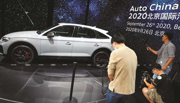 People take pictures of the Audi Q5 L Sportback at the Beijing International Automotive Exhibition, or Auto China show, in Beijing yesterday.