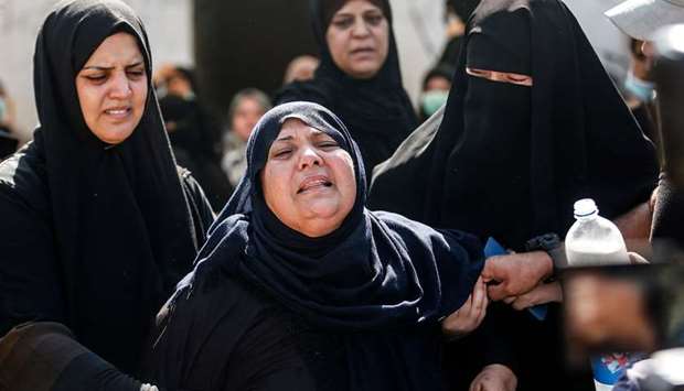 Mourners comfort the mother of two Palestinian fishermen who were shot at sea, during their funeral in Deir al-Balah in the central Gaza Strip, yesterday.