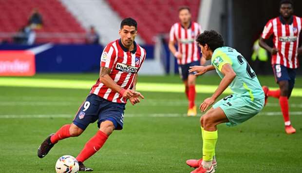 Granadau2019s Spanish defender Jesus Vallejo challenges Atletico Madridu2019s Uruguayan forward Luis Suarez (Left) during the La Liga in Madrid yesterday. (AFP)