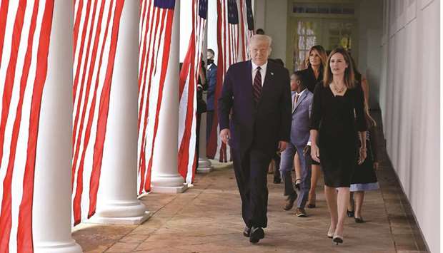 US President Donald Trump and judge Amy Coney Barrett arrive at the Rose Garden of the White House in Washington, DC.