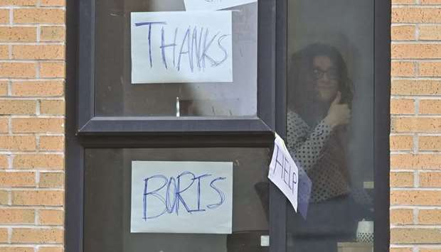 A student gestures at the window of the Birley Halls student accommodation, for students at Manchester Metropolitan University, in Manchester, yesterday, as many students live in a temporary lockdown in a bid to reduce the spread of the novel coronavirus on the campus.