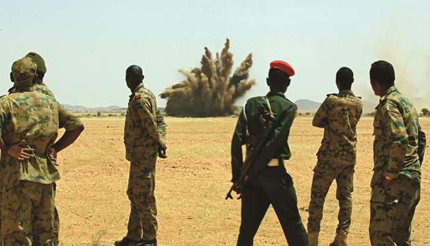 Members of the Sudanese army stand as weapons that were collected from Sudanese citizens are destroyed in the Hajar Al Assal base, the Nile River State, 200kms north of the capital Khartoum, yesterday.