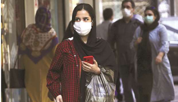 A woman, mask-clad as a coronavirus pandemic precaution, walks past shops along a street in Iranu2019s capital Tehran on September 27. The Trump administration is considering targeting more than a dozen banks and labelling Iranu2019s entire financial sector off limits, three people familiar with the matter said on Monday.
