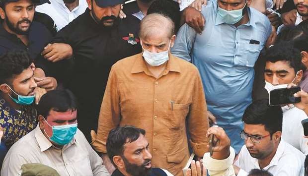 Security officials escort Shehbaz Sharif at the National Accountability Bureau (NAB) court in Lahore. Anti-corruption officials arrested the Opposition Leader on Monday.